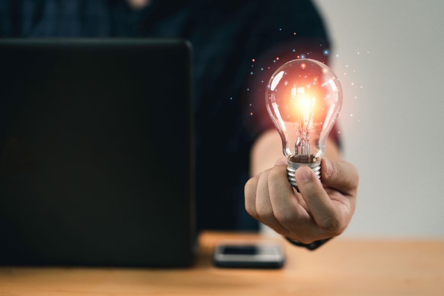 man holding lightbulb with glowing light