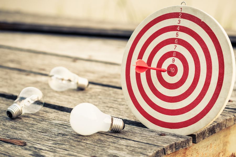 lightbulb dart and board on wooden table