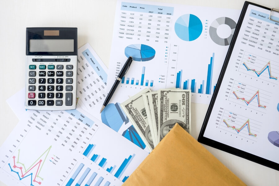 business reports with calculator pen and money bills