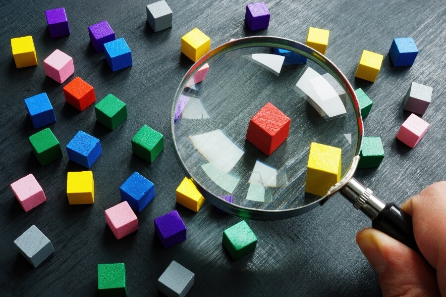 hand holding magnifying glass to see bricks