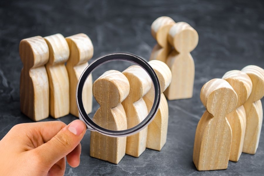 magnifying glass zooming in on wooden figurine