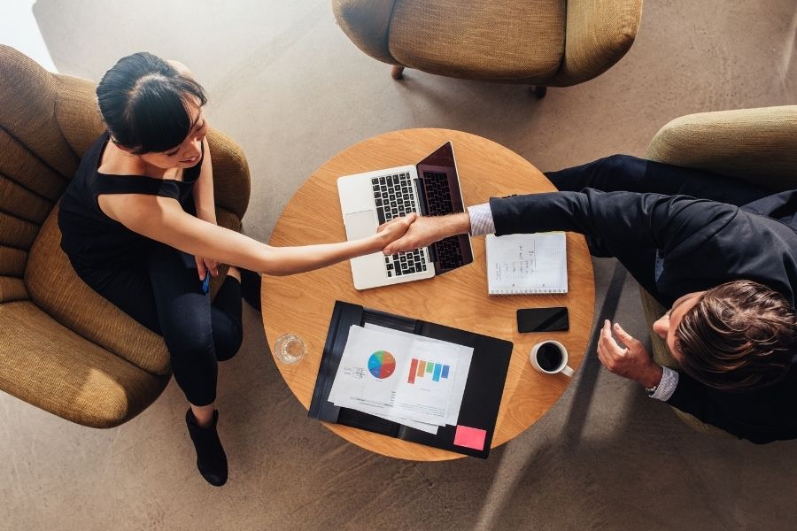 two people handshaking while sitting