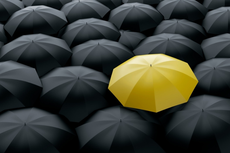 yellow umbrella surrounded by black ones
